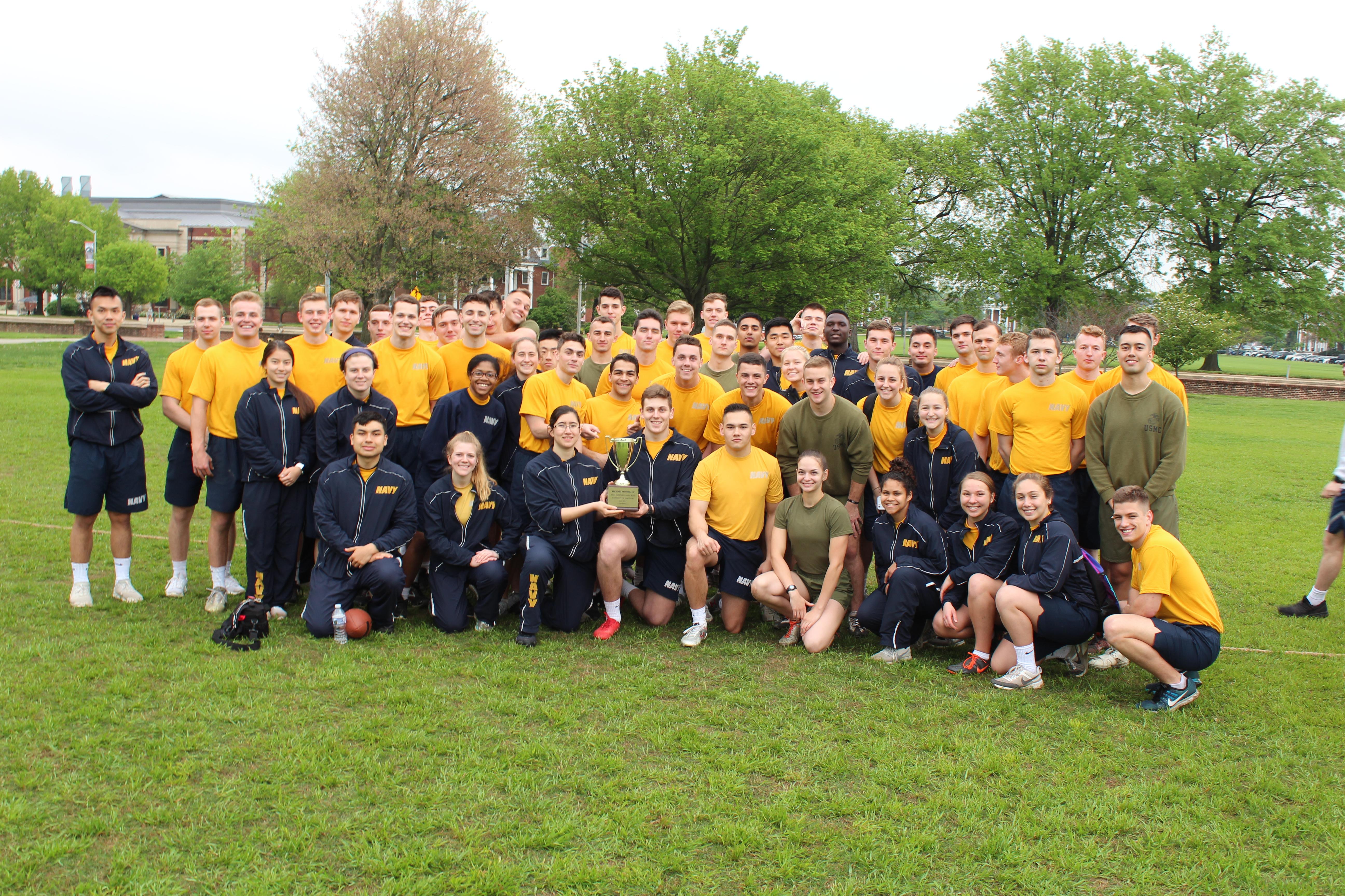 Midshipmen in PT gear on Chapel Fields holding the Armory Cup after beating Army and Air Force ROTC